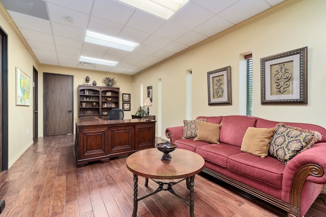 living room with hardwood / wood-style flooring, a drop ceiling, and ornamental molding