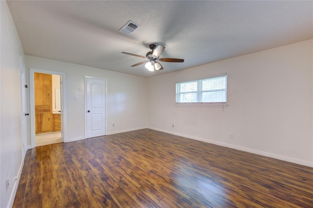 empty room with ceiling fan, dark hardwood / wood-style flooring, and a textured ceiling