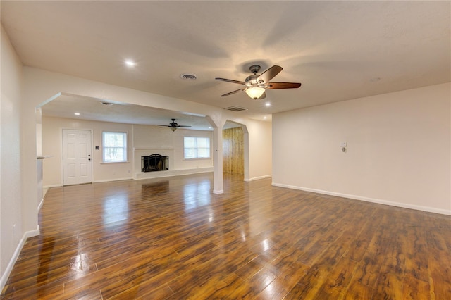 unfurnished living room featuring ceiling fan and dark wood-type flooring