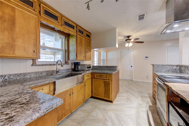 kitchen featuring light stone countertops, kitchen peninsula, ceiling fan, electric stove, and plenty of natural light