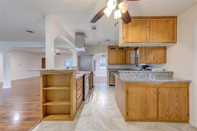 kitchen with light stone counters, kitchen peninsula, stainless steel appliances, and light hardwood / wood-style flooring