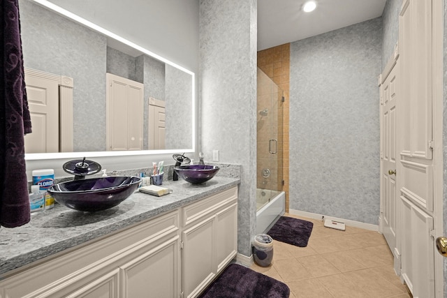 bathroom featuring tile patterned flooring, vanity, and shower / bath combination with glass door