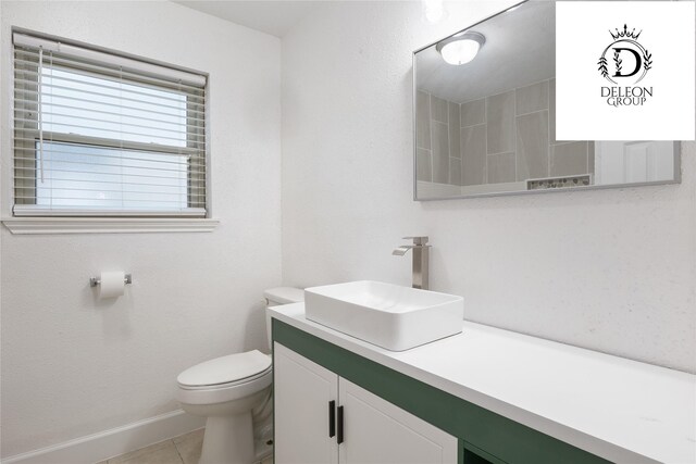 bathroom with tile patterned flooring, vanity, and toilet