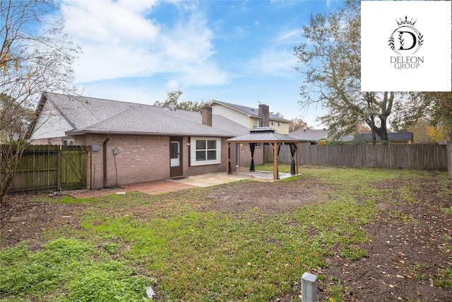 rear view of house with a gazebo, a patio, and a lawn