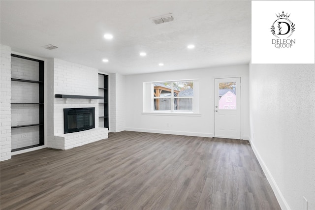 unfurnished living room featuring a fireplace and dark wood-type flooring