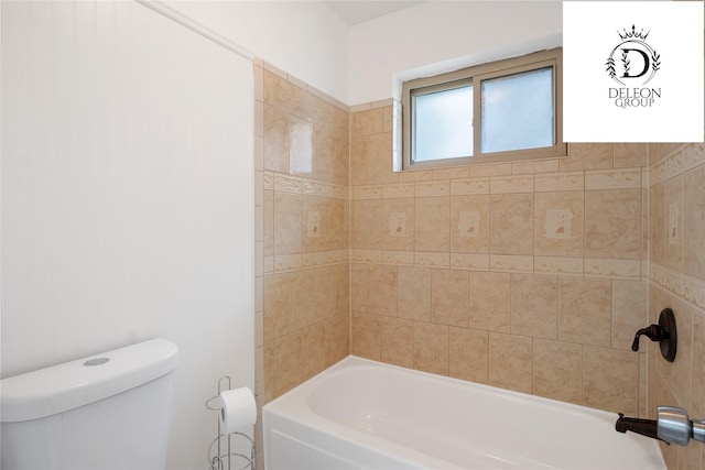 bathroom featuring tiled shower / bath combo and toilet