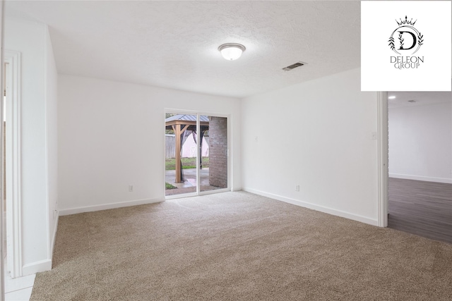 spare room featuring carpet floors and a textured ceiling