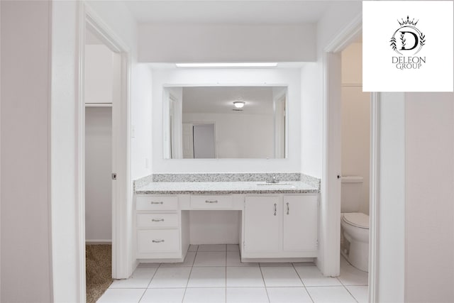 bathroom with tile patterned flooring, vanity, and toilet