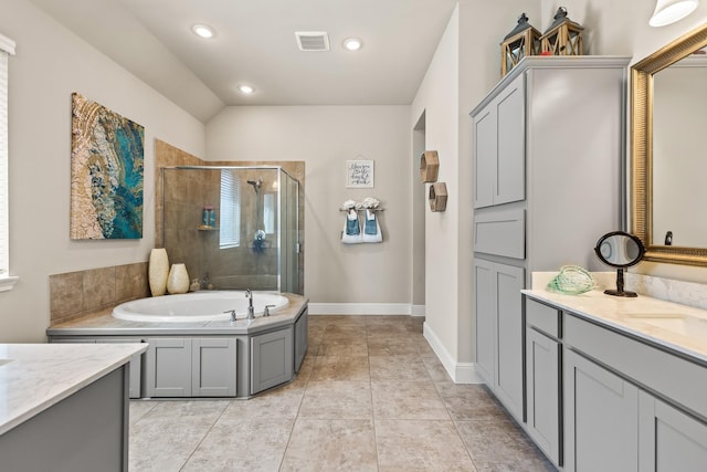 bathroom with shower with separate bathtub, vanity, vaulted ceiling, and tile patterned floors