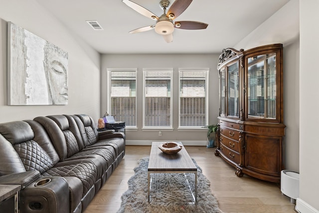 living room featuring light hardwood / wood-style flooring and ceiling fan