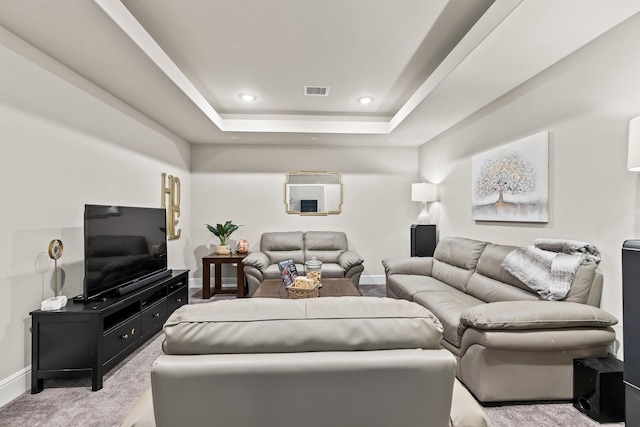 carpeted living room featuring a raised ceiling