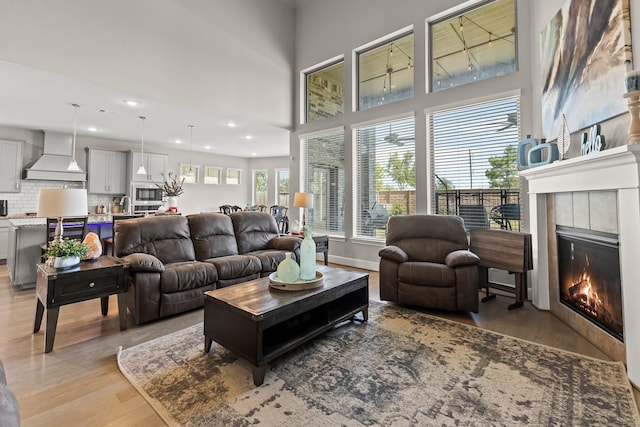 living room with light hardwood / wood-style floors, sink, and a tile fireplace