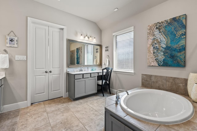 bathroom with tile patterned flooring, vanity, a bathtub, and lofted ceiling