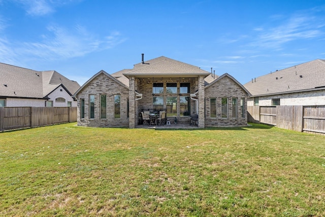 back of house with a yard and a patio