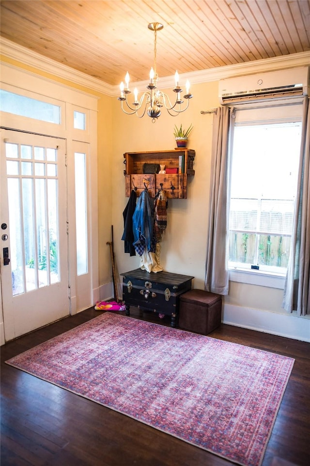 foyer entrance with dark hardwood / wood-style flooring, an AC wall unit, crown molding, and an inviting chandelier