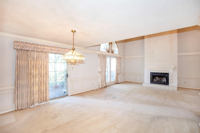 unfurnished living room with a tile fireplace, carpet floors, and a chandelier