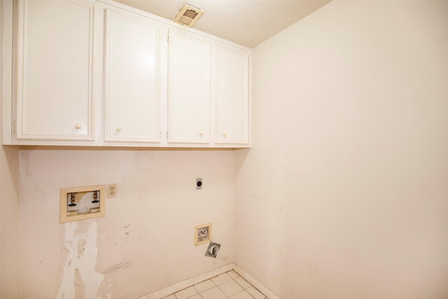 clothes washing area with electric dryer hookup, light tile patterned floors, cabinets, and washer hookup