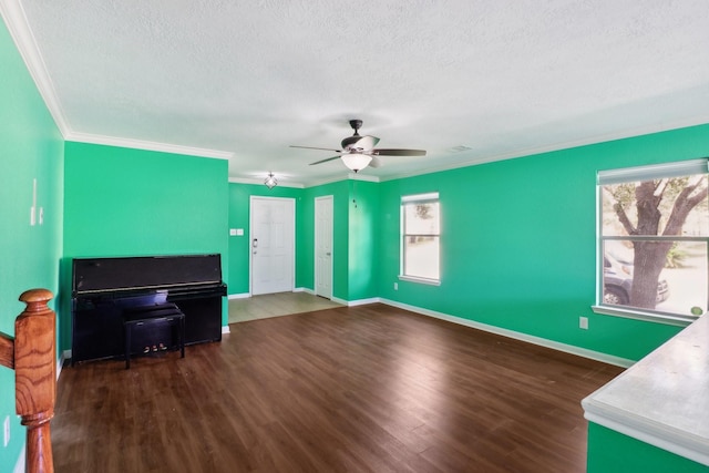 living room with ceiling fan, crown molding, dark wood-type flooring, and a textured ceiling