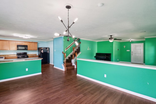 kitchen with dark wood-type flooring, black appliances, ceiling fan with notable chandelier, crown molding, and hanging light fixtures