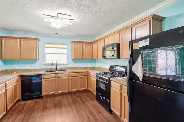 kitchen featuring sink, hardwood / wood-style flooring, crown molding, and black appliances