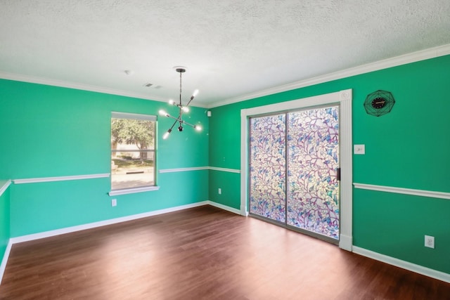 unfurnished dining area featuring a healthy amount of sunlight, dark wood-type flooring, crown molding, and a notable chandelier