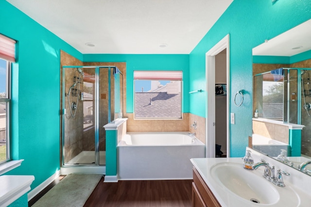 bathroom featuring hardwood / wood-style floors, vanity, and separate shower and tub