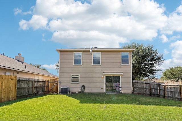 back of property featuring a lawn and central air condition unit