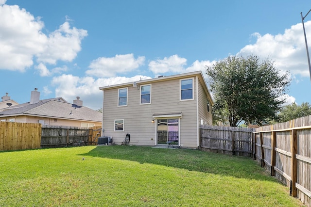 back of house with a yard and central AC