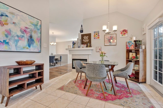 tiled dining room featuring vaulted ceiling and a notable chandelier