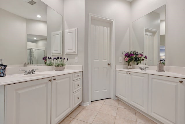 bathroom with tile patterned flooring, vanity, and a shower with door