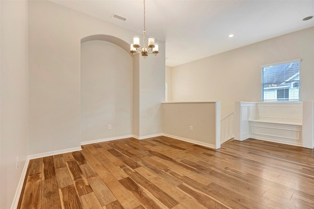 unfurnished room featuring hardwood / wood-style floors and an inviting chandelier