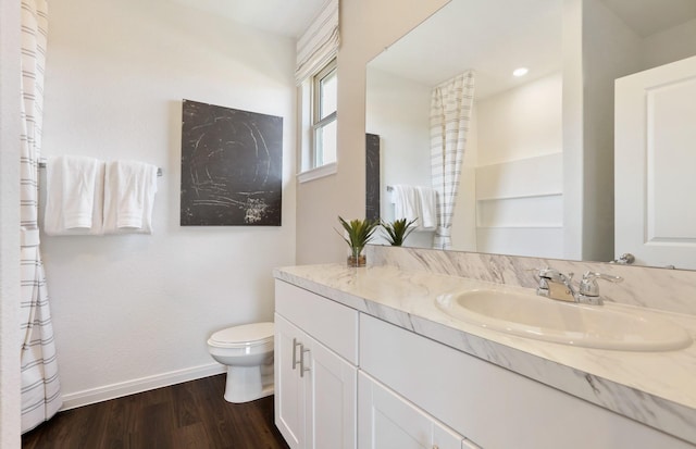 bathroom with hardwood / wood-style flooring, vanity, and toilet