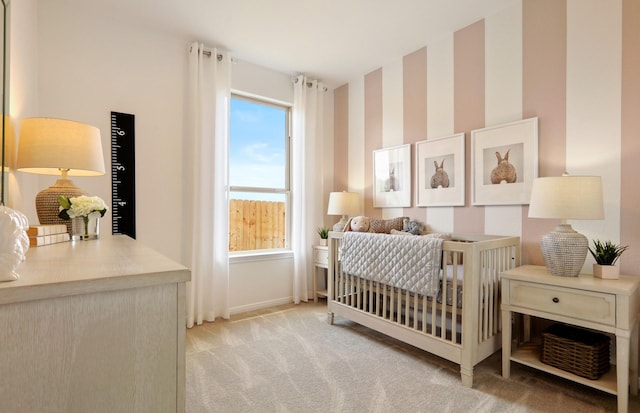 carpeted bedroom featuring a nursery area