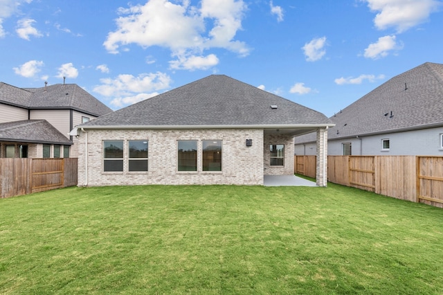 rear view of house with a yard and a patio