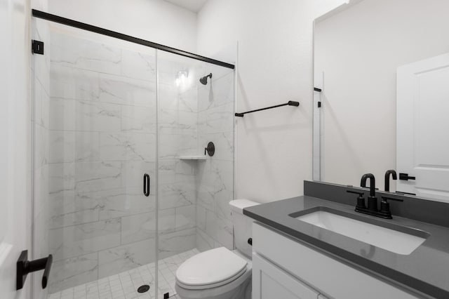 bathroom with vanity, a shower with shower door, and toilet