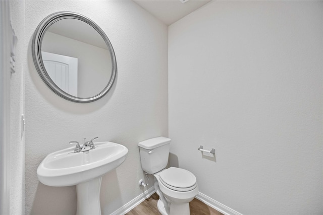 bathroom with toilet and hardwood / wood-style flooring