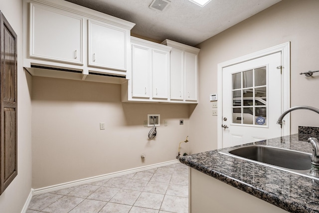 washroom featuring electric dryer hookup, cabinets, hookup for a gas dryer, sink, and a textured ceiling