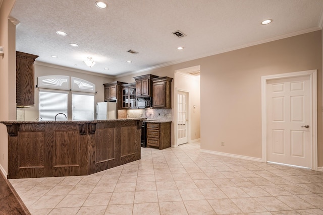 kitchen featuring light tile patterned floors, backsplash, white fridge, and a textured ceiling