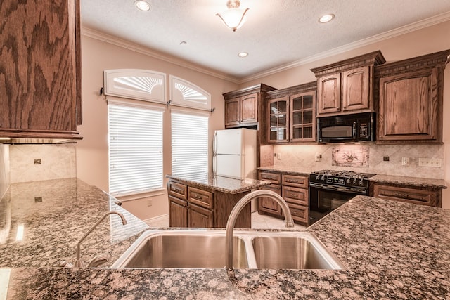 kitchen with backsplash, ornamental molding, sink, black appliances, and dark stone countertops