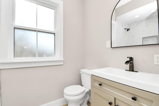 bathroom with plenty of natural light, vanity, and toilet