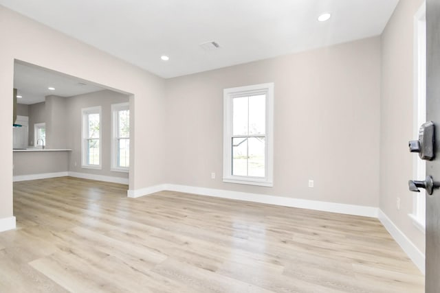 empty room with light wood-type flooring and plenty of natural light