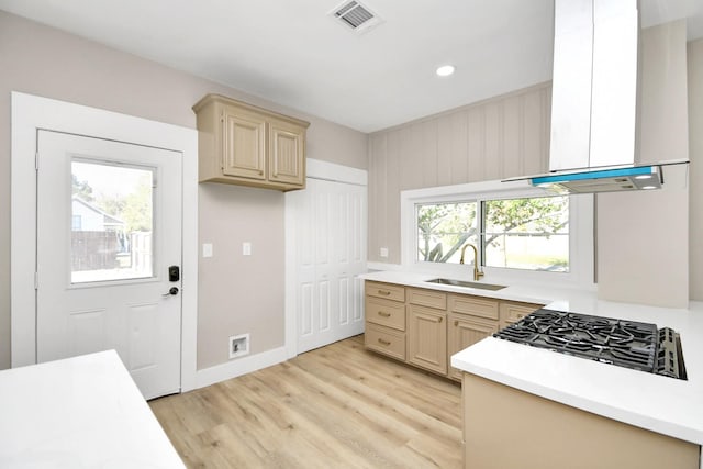 kitchen featuring light brown cabinetry, gas stovetop, exhaust hood, sink, and light hardwood / wood-style floors