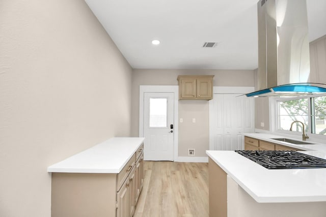 kitchen featuring island exhaust hood, light brown cabinetry, light wood-type flooring, gas cooktop, and sink