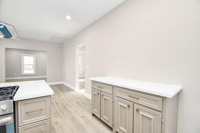 kitchen with cream cabinetry, light hardwood / wood-style floors, and stainless steel gas range