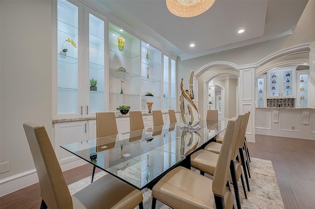 dining area with dark wood-type flooring and crown molding