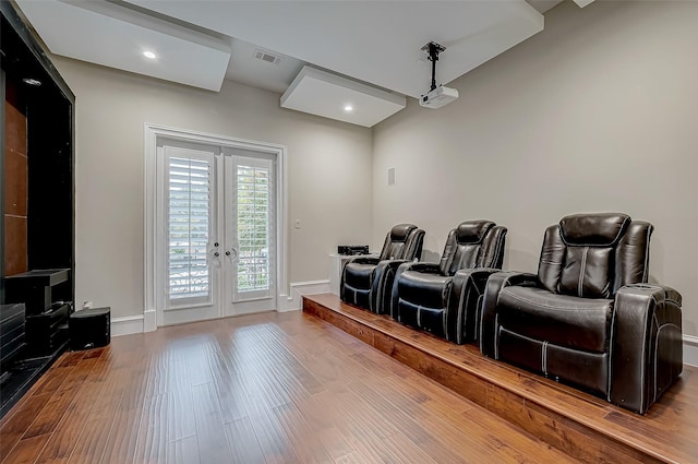 cinema room featuring wood finished floors, visible vents, baseboards, recessed lighting, and french doors