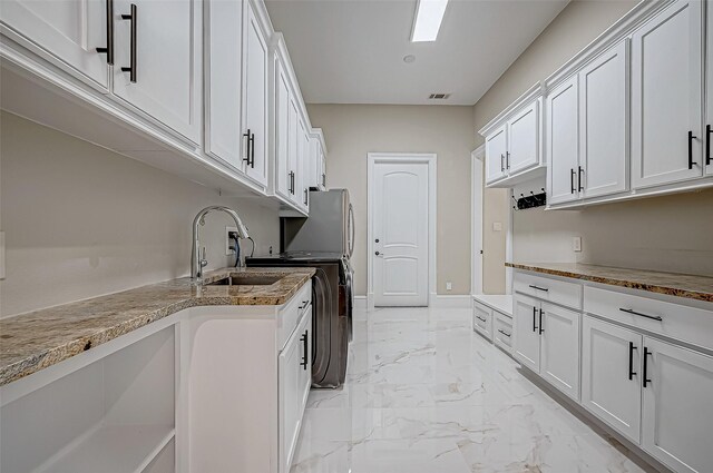 kitchen with white cabinetry and light stone counters