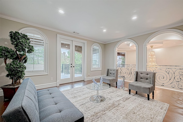 living room with visible vents, french doors, crown molding, and wood-type flooring