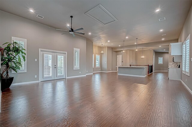 unfurnished living room featuring ceiling fan, french doors, sink, and hardwood / wood-style flooring