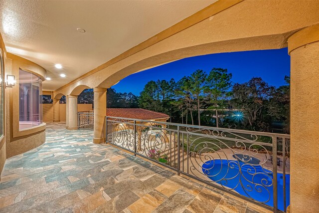 patio at night featuring a balcony